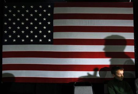 Republican presidential candidate and former Massachusetts Governor Mitt Romney casts a shadow on a U.S. flag while speaking at a ''We the People Freedom Forum'' in Hudson, New Hampshire December 11, 2011. CREDIT: REUTERS/BRIAN SNYDER Republican presidential candidate and former Massachusetts Governor Mitt Romney casts a shadow on a U.S. flag while speaking at a ''We the People Freedom Forum'' in Hudson, New Hampshire December 11, 2011. CREDIT: REUTERS/BRIAN SNYDER