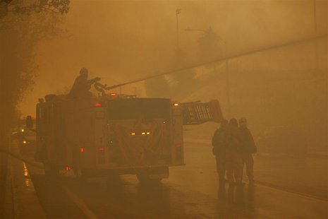 Firefighters protect homes as a wildfire driven by fierce Santa Ana winds blows in Rancho Cucamonga, California, April 30, 2014. REUTERS/Dav Firefighters protect homes as a wildfire driven by fierce Santa Ana winds blows in Rancho Cucamonga, California, April 30, 2014. REUTERS/Dav
