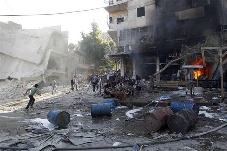 Residents run after, according to activists, two barrel bombs were thrown by forces loyal to Syria's president Bashar Al-Assad in Hullok nei Residents run after, according to activists, two barrel bombs were thrown by forces loyal to Syria's president Bashar Al-Assad in Hullok nei