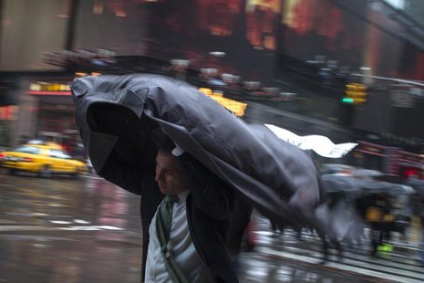 A man uses his rain coat to guard against rain and wind as he commutes through Times Square, New York April 30, 2014. REUTERS/Adrees Latif A man uses his rain coat to guard against rain and wind as he commutes through Times Square, New York April 30, 2014. REUTERS/Adrees Latif