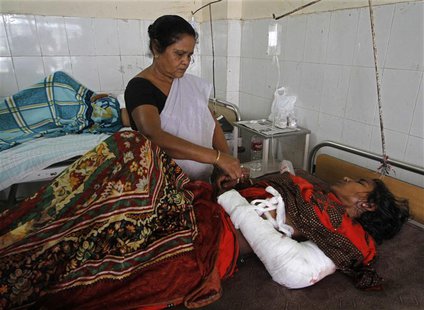 A member of medical staff tends to Phuleja Khatun, 25, who was injured in an attack, inside a hospital in the northeastern Indian city of Gu A member of medical staff tends to Phuleja Khatun, 25, who was injured in an attack, inside a hospital in the northeastern Indian city of Gu