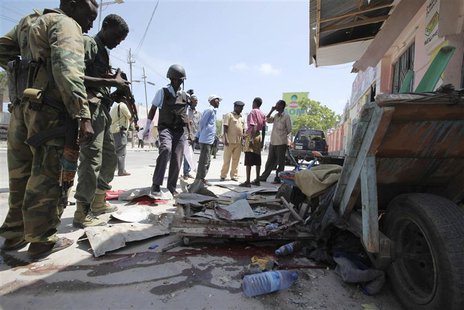 Somali soldiers stand at the scene of an explosion in the capital Mogadishu May 3, 2014. At least three people were killed and several wound Somali soldiers stand at the scene of an explosion in the capital Mogadishu May 3, 2014. At least three people were killed and several wound
