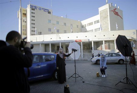 Palestinian students hold a photo shoot in front of a post office building in East Jerusalem April 29, 2014. REUTERS/Ammar Awad Palestinian students hold a photo shoot in front of a post office building in East Jerusalem April 29, 2014. REUTERS/Ammar Awad