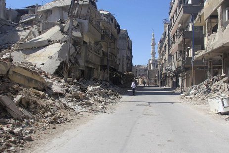 A resident walks past damaged buildings in the Damascus suburb of Zamalka May 2, 2014. Picture taken May 2, 2014. REUTERS/Badra Mamet A resident walks past damaged buildings in the Damascus suburb of Zamalka May 2, 2014. Picture taken May 2, 2014. REUTERS/Badra Mamet