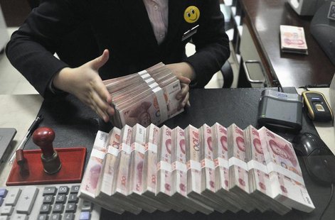 A clerk arranges bundles of 100 Chinese yuan banknotes at a branch of China Merchants Bank in Hefei, Anhui province March 17, 2014. REUTERS/ A clerk arranges bundles of 100 Chinese yuan banknotes at a branch of China Merchants Bank in Hefei, Anhui province March 17, 2014. REUTERS/