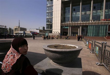 A Uighur woman looks back near exit of the South Railway Station, where three people were killed and 79 wounded in Wednesday's bomb and knif A Uighur woman looks back near exit of the South Railway Station, where three people were killed and 79 wounded in Wednesday's bomb and knif