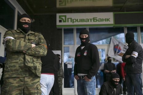 Masked pro-Russian activists stand outside a branch of Ukraine's Privatbank during a protest in Donetsk, eastern Ukraine April 28, 2014. REU Masked pro-Russian activists stand outside a branch of Ukraine's Privatbank during a protest in Donetsk, eastern Ukraine April 28, 2014. REU