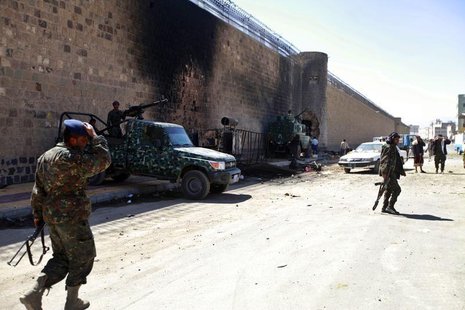 Policemen stand guard next to a wall of the central prison in Sanaa after a bomb exploded outside, February 14, 2014. REUTERS/Mohamed al-Say Policemen stand guard next to a wall of the central prison in Sanaa after a bomb exploded outside, February 14, 2014. REUTERS/Mohamed al-Say