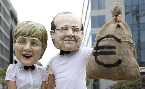 Activists wearing masks depicting German Chancellor Angela Merkel (L) and French President Francois Hollande stage a protest outside a meeti Activists wearing masks depicting German Chancellor Angela Merkel (L) and French President Francois Hollande stage a protest outside a meeti