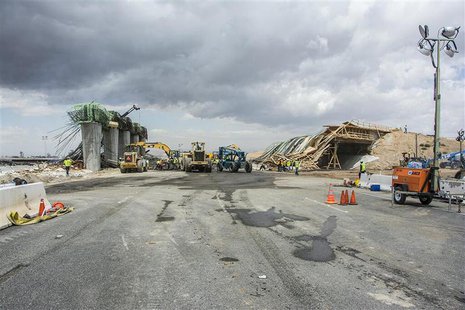 Construction crew continue to clear the scene in the aftermath of a fire and subsequent collapse of a highway overpass that closed the Inter Construction crew continue to clear the scene in the aftermath of a fire and subsequent collapse of a highway overpass that closed the Inter