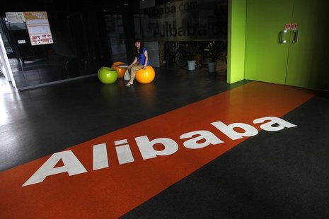 An employee sits next to a logo of Alibaba during a media tour organised by government officials at the company's headquarters on the outski An employee sits next to a logo of Alibaba during a media tour organised by government officials at the company's headquarters on the outski