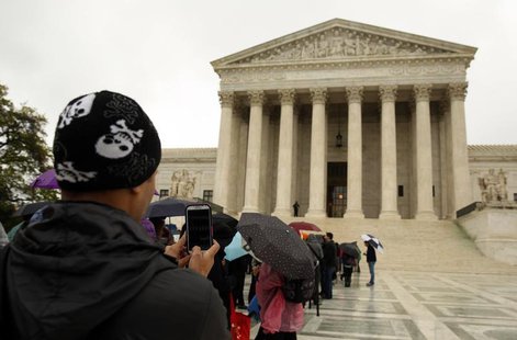 A man takes a picture with his mobile device outside of the U.S. Supreme Court in Washington April 29, 2014. REUTERS/Gary Cameron A man takes a picture with his mobile device outside of the U.S. Supreme Court in Washington April 29, 2014. REUTERS/Gary Cameron