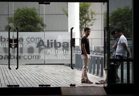 Employees stand next to a glass door with logos of Alibaba during a media tour organised by government officials at the company's headquarte Employees stand next to a glass door with logos of Alibaba during a media tour organised by government officials at the company's headquarte