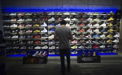 A man stands in front of a rack with Adidas Original shoes before the opening at the new Adidas Originals store in Berlin, March 27, 2014. R A man stands in front of a rack with Adidas Original shoes before the opening at the new Adidas Originals store in Berlin, March 27, 2014. R