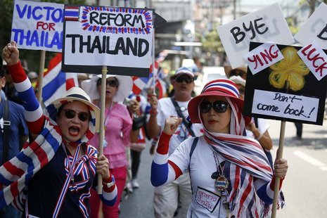 Anti-government protesters carry signs against ousted Prime Minister Yingluck Shinawatra as they march in central Bangkok May 8, 2014. REUTE Anti-government protesters carry signs against ousted Prime Minister Yingluck Shinawatra as they march in central Bangkok May 8, 2014. REUTE