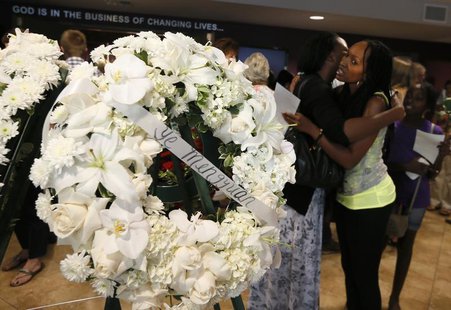 Women embrace near wreaths after a prayer vigil for the victims 0f the Asiana Airlines crash at West Valley Christian School in West Hills, Women embrace near wreaths after a prayer vigil for the victims 0f the Asiana Airlines crash at West Valley Christian School in West Hills,