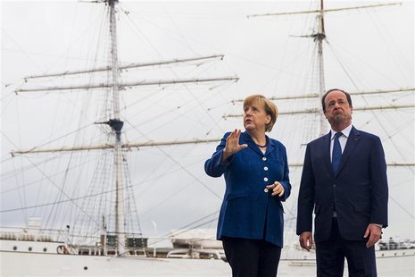 German Chancellor Angela Merkel (L) and French President Francois Hollande pose for pictures in front of the tall ship Gorch Fock I, in the German Chancellor Angela Merkel (L) and French President Francois Hollande pose for pictures in front of the tall ship Gorch Fock I, in the