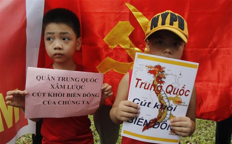 Boys hold placards which read "Chinese invaders, get out of the East Sea (South China Sea)" (L) and "China get out, East Sea", in front of t Boys hold placards which read "Chinese invaders, get out of the East Sea (South China Sea)" (L) and "China get out, East Sea", in front of t