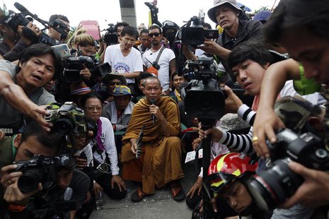 Thai Buddhist monk and protest leader Luang Pu Buddha Issara (C) is surrounded by his supporters and reporters as anti-government protesters Thai Buddhist monk and protest leader Luang Pu Buddha Issara (C) is surrounded by his supporters and reporters as anti-government protesters