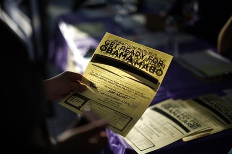 A woman picks up a leaflet at a health insurance enrollment event in Cudahy, California March 27, 2014. REUTERS/Lucy Nicholson A woman picks up a leaflet at a health insurance enrollment event in Cudahy, California March 27, 2014. REUTERS/Lucy Nicholson