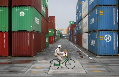 A worker rides a bicycle in a container area at a port in Tokyo April 21, 2014. REUTERS/Toru Hanai A worker rides a bicycle in a container area at a port in Tokyo April 21, 2014. REUTERS/Toru Hanai