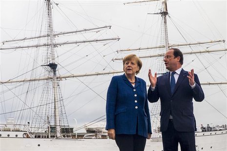 German Chancellor Angela Merkel (L) and French President Francois Hollande pose for pictures in front of the tall ship Gorch Fock I, in the German Chancellor Angela Merkel (L) and French President Francois Hollande pose for pictures in front of the tall ship Gorch Fock I, in the