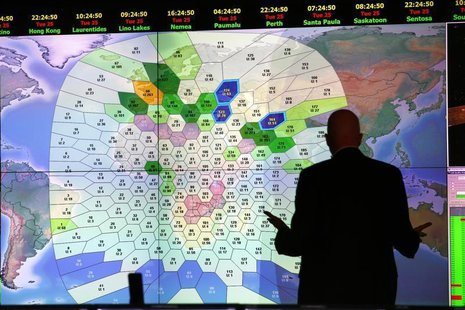 A member of staff at satellite communications company Inmarsat works in front of a screen showing subscribers using their service throughout A member of staff at satellite communications company Inmarsat works in front of a screen showing subscribers using their service throughout