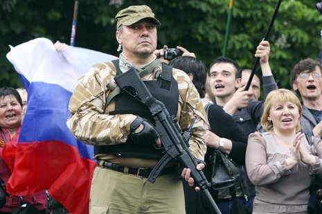 A bodyguard hold his weapon during a rally to mark and celebrate the announcement of the results of the referendum on the status of Luhansk A bodyguard hold his weapon during a rally to mark and celebrate the announcement of the results of the referendum on the status of Luhansk