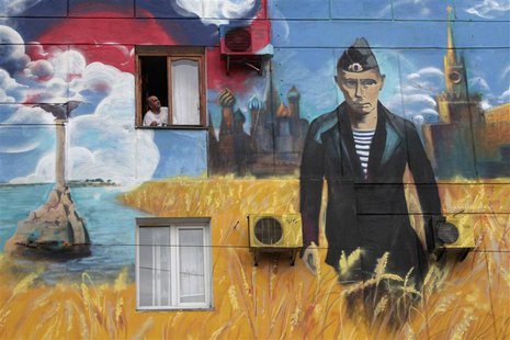 A man looks out of his window surrounded by a recently created graffiti depicting the Kremlin, Russia's President Vladimir Putin and the Rus A man looks out of his window surrounded by a recently created graffiti depicting the Kremlin, Russia's President Vladimir Putin and the Rus