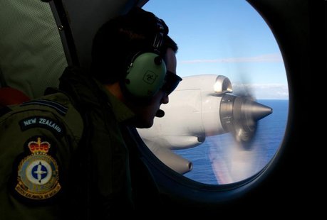 Flight Lieutenant Jamin Baker looks out an observation window aboard a Royal New Zealand Air Force (RNZAF) P3 Orion maritime search aircraft Flight Lieutenant Jamin Baker looks out an observation window aboard a Royal New Zealand Air Force (RNZAF) P3 Orion maritime search aircraft