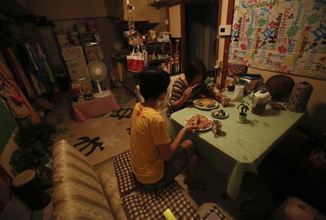 Ririko Saito and her 11-year-old daughter Yumi eat dinner together, one of only two meals they have a day in an attempt to keep household co Ririko Saito and her 11-year-old daughter Yumi eat dinner together, one of only two meals they have a day in an attempt to keep household co