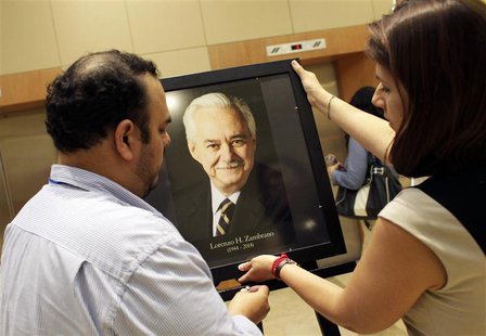 Employees hold a photograph of Lorenzo Zambrano at a building of Mexican cement giant Cemex in Monterrey May 13, 2014. REUTERS/Daniel Becerr Employees hold a photograph of Lorenzo Zambrano at a building of Mexican cement giant Cemex in Monterrey May 13, 2014. REUTERS/Daniel Becerr