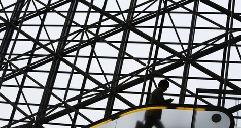 A man holding a mobile phone rides an escalator in Tokyo August 11, 2013. REUTERS/Yuya Shino A man holding a mobile phone rides an escalator in Tokyo August 11, 2013. REUTERS/Yuya Shino