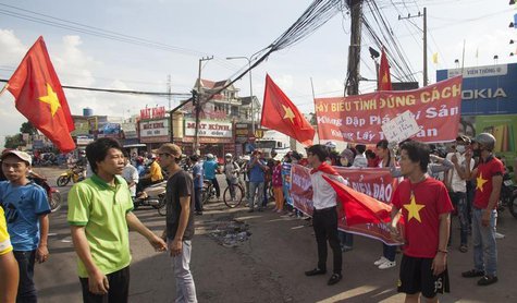 Workers wave Vietnamese national flags during a protest at an industrial zone in Binh Duong province May 14, 2014. REUTERS/Stringer