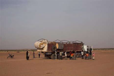 Nigeriens, who are travelling north in the direction of Libya, board a truck in Agadez March 17, 2014. Picture taken March 17, 2014. REUTERS Nigeriens, who are travelling north in the direction of Libya, board a truck in Agadez March 17, 2014. Picture taken March 17, 2014. REUTERS