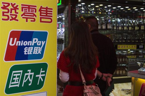 Chinese visitors walk past a sign for China UnionPay outside a pawnshop in Macau, in this November 20, 2013 file photo. REUTERS/Tyrone Siu/F Chinese visitors walk past a sign for China UnionPay outside a pawnshop in Macau, in this November 20, 2013 file photo. REUTERS/Tyrone Siu/F