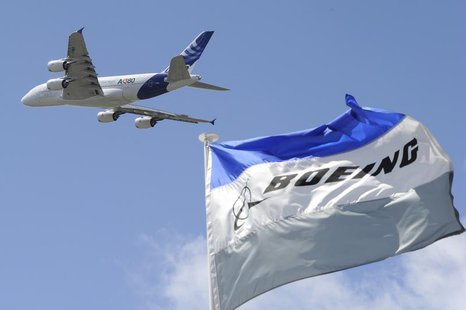 Boeing flags flutter as an Airbus A380, the world's largest jetliner, takes part in a flying display during the 49th Paris Air Show at the L Boeing flags flutter as an Airbus A380, the world's largest jetliner, takes part in a flying display during the 49th Paris Air Show at the L