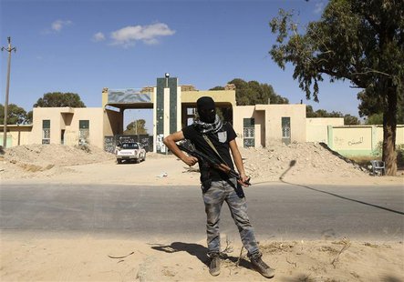 A militia stands guard in front of the entrance to the February 17 militia camp after Libyan irregular forces clashed with them in the easte A militia stands guard in front of the entrance to the February 17 militia camp after Libyan irregular forces clashed with them in the easte