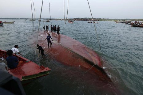 Rescue workers stand on the partially salvaged M.V. Miraj-4 ferry after it capsized on the Meghna river at Rasulpur in Munshiganj district M Rescue workers stand on the partially salvaged M.V. Miraj-4 ferry after it capsized on the Meghna river at Rasulpur in Munshiganj district M