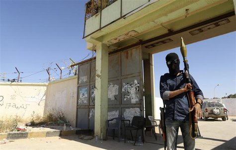 A militia stands guard in front of the entrance to the February 17 militia camp after Libyan irregular forces clashed with them in the easte A militia stands guard in front of the entrance to the February 17 militia camp after Libyan irregular forces clashed with them in the easte