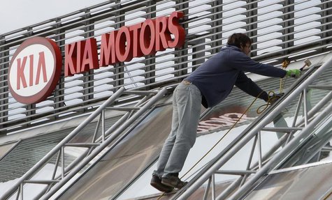 A worker repairs a roof next to a Kia Motors logo in Prague October 9, 2012. REUTERS/David W Cerny A worker repairs a roof next to a Kia Motors logo in Prague October 9, 2012. REUTERS/David W Cerny