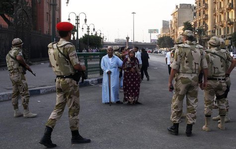 Pedestrians look as the Egyptian army soldiers divert traffic away from the front of the Egyptian museum in Cairo, July 9, 2013. REUTERS/Asm Pedestrians look as the Egyptian army soldiers divert traffic away from the front of the Egyptian museum in Cairo, July 9, 2013. REUTERS/Asm