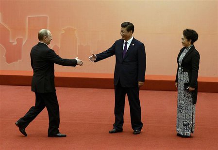 Russian President Vladimir Putin (L) is greeted by the Chinese President Xi Jinping (C) and his wife Peng Liyuan before the group photo even Russian President Vladimir Putin (L) is greeted by the Chinese President Xi Jinping (C) and his wife Peng Liyuan before the group photo even