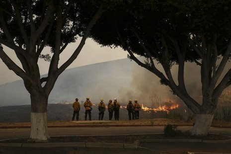 Firefighters watch the Las Pulgas Fire at Camp Pendleton, California in this May 16, 2014 handout photo from the USMC. REUTERS/Cpl. Sarah Wo Firefighters watch the Las Pulgas Fire at Camp Pendleton, California in this May 16, 2014 handout photo from the USMC. REUTERS/Cpl. Sarah Wo