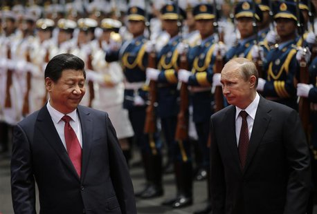 Russia's President Vladimir Putin (R) and China's President Xi Jinping review an honour guard contingent during a welcoming ceremony at the Russia's President Vladimir Putin (R) and China's President Xi Jinping review an honour guard contingent during a welcoming ceremony at the