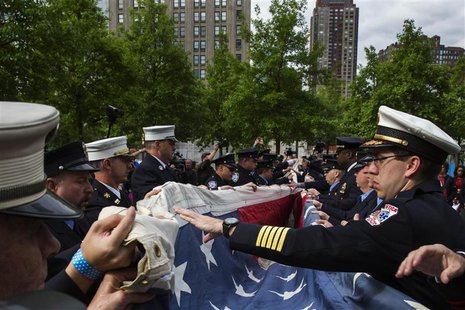 Members of an honor guard fold the National 9/11 Flag, donated by New York Says Thank You Foundation, on the grounds of the 9/11 Memorial Pl Members of an honor guard fold the National 9/11 Flag, donated by New York Says Thank You Foundation, on the grounds of the 9/11 Memorial Pl