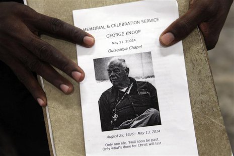 A person holds a flyer announcing a memorial service for U.S. missionary George Knoop, an elder with the Quisqueya Chapel, during the servic A person holds a flyer announcing a memorial service for U.S. missionary George Knoop, an elder with the Quisqueya Chapel, during the servic