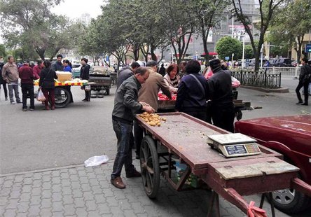 Vendors undersell fruits at an open market near the site of a blast in Urumqi, Xinjiang Uyghur Autonomous Region May 22, 2014. REUTERS/CNSph Vendors undersell fruits at an open market near the site of a blast in Urumqi, Xinjiang Uyghur Autonomous Region May 22, 2014. REUTERS/CNSph