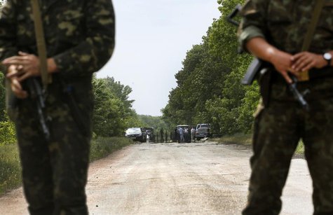 Ukrainian soldiers secure an area near the site (seen in background) where pro-Russian rebels killed thirteen Ukrainian servicemen in the ou Ukrainian soldiers secure an area near the site (seen in background) where pro-Russian rebels killed thirteen Ukrainian servicemen in the ou