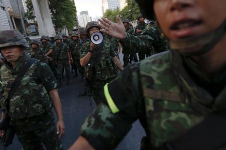 Soldiers try to control a crowd protesting against military rule in central Bangkok, a day after the Thai army chief seized power in a coup Soldiers try to control a crowd protesting against military rule in central Bangkok, a day after the Thai army chief seized power in a coup